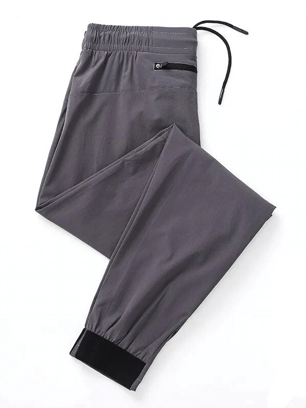 Quick-drying men's sports pants with zippered pockets in gray, perfect for running and workouts, featuring elastic waist.